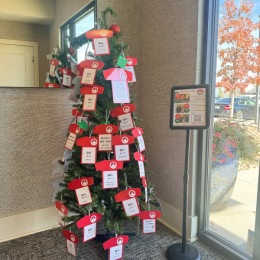 a Christmas tree decorated with red and white sponsorship items