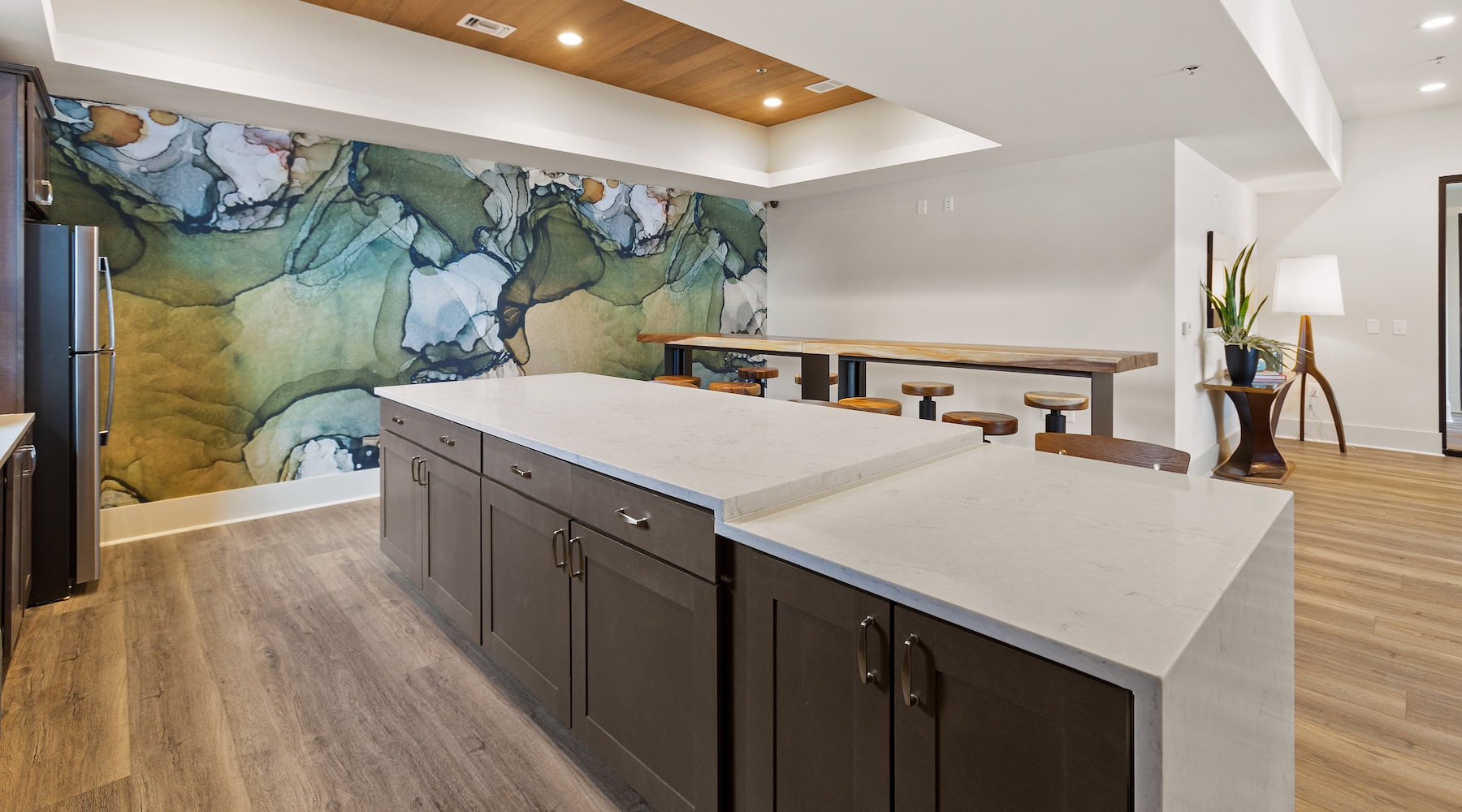 Large well lit lounge area with kitchen and bar seating 